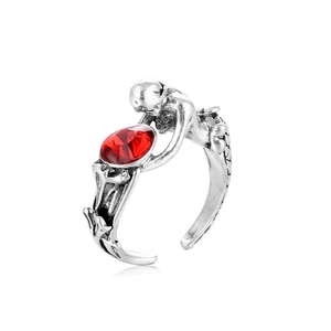 Punk style mermaid silver ring with large red oval gemstone on a white background
