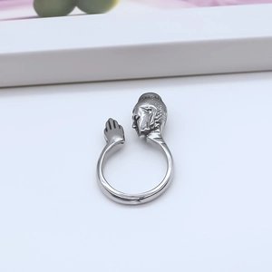 Macro detail of silver Buddha head and hands prayer pose on adjustable open ring band