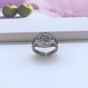 Macro detail of vintage silver Tai Chi Bagua ring with adjustable band on white surface