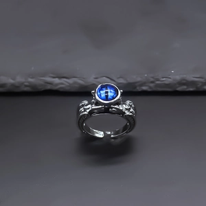 Detailed view of Gothic evil eye ring with blue pupil stone and silver scale texture