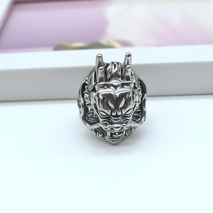 Detailed close-up of an intricate silver dragon head ring with carved scales and punk style