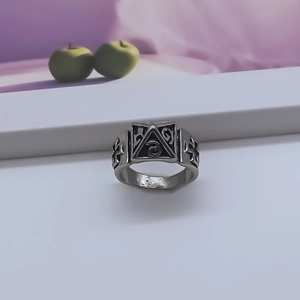 Detailed macro view of retro silver ring featuring engraved pyramid and cross patterns