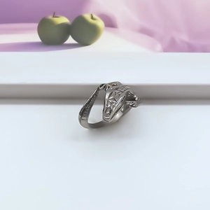 Detail of vintage silver punk open ring with embossed lizard design on white steps