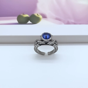 Front view of vintage silver-tone ring with blue cat-eye stone and ornate carvings
