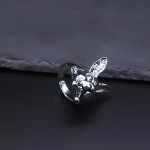 Macro detail of the punk style adjustable alloy dog head ring on a textured stone background