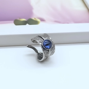 Macro detail of silver feather texture ring with a blue cat-eye stone inlay