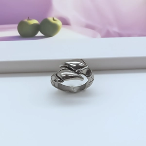 Close-up of vintage silver punk ring with abstract dolphin shape on a white pedestal
