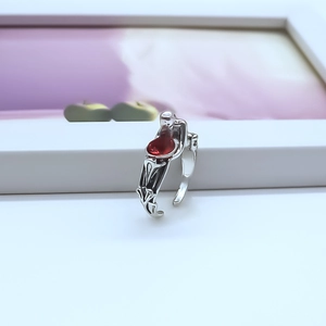 Close-up of silver punk ring with teardrop red stone and intricate side carvings
