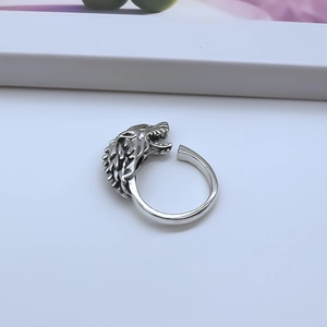 Macro detail of retro silver wolf head ring with intricate punk style engravings