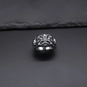Close-up of vintage silver punk ring featuring an embossed cross with antique finish