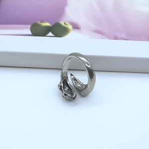 Macro shot of silver punk skull ring featuring detailed feline relief and adjustable band