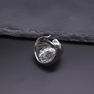 Gros plan sur une bague vintage argentée avec texture de lave irrégulière et polie
