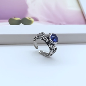 Vintage adjustable alloy feather ring featuring a blue gemstone center on white surface