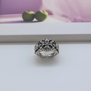 Detailed view of punk style open ring with vintage cross engraving and blackened finish