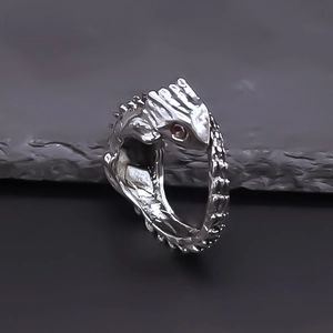 Close-up of vintage silver lizard ring with red gemstone eyes and scale texture