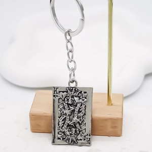 Macro detail of vintage silver-tone alloy keychain featuring an ornate King poker card pendant