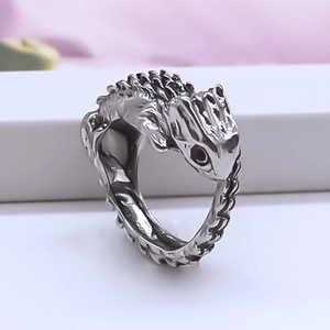 Detail of vintage gecko ring in antique silver alloy with scales and red eyes