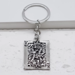 Silver vintage poker King K pendant keychain with embossed texture on white background