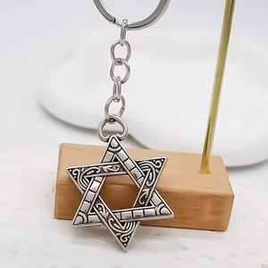 Creative silver hexagram star keychain with vintage engraved patterns on a metal stand