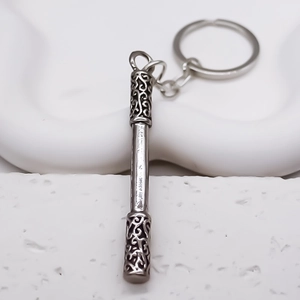 Detailed macro view of ancient silver metal monkey king bar keychain with engraved clouds