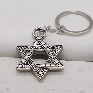 Detail of silver hexagram keychain with intricate Celtic knot engraving and vintage finish