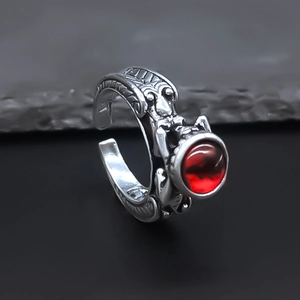 Macro view of vintage silver ring with red gemstone and intricate skull carvings