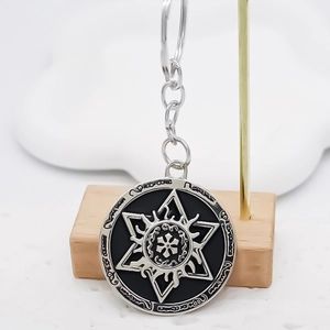 Close-up of alloy keychain with double-tone round pendant featuring mystic sun runes engraving
