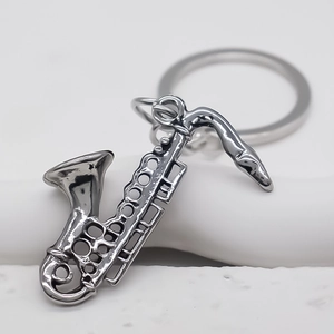 Macro view of polished silver saxophone keychain with glossy metallic finish and ring