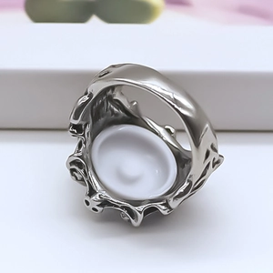 Detailed top view of retro silver metal ring with intricate gothic engravings on a white base