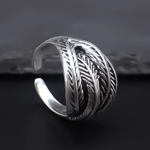 Close-up of vintage silver feather ring with detailed punk style texture and aged finish