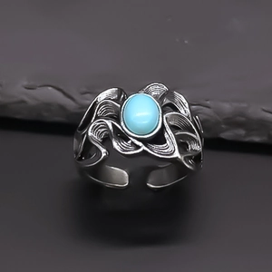 Close-up of vintage open ring with oval turquoise stone and flame hollow pattern