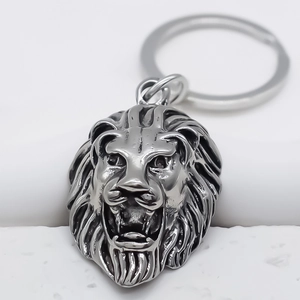 Detailed lion head keychain made of vintage grey metal on a clean white background
