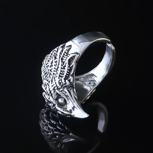 Detailed close-up of eagle head ring with realistic feather textures and open band
