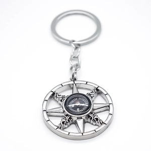 Creative silver metal keychain with a sunburst star frame and black magnetic compass
