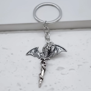 Gros plan du pendentif épée de dragon en argent antique sur une surface en pierre