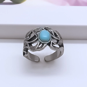 Detailed close-up of retro silver-tone ring with turquoise stone and ornate wing design
