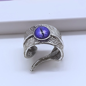 Vintage silver feather ring featuring a purple cat eye stone and adjustable opening