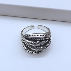 Detailed view of vintage silver feather ring showing oxidized textures and adjustable band