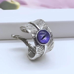 Macro shot of vintage silver feather ring with a purple evil eye cat eye gemstone