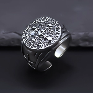 Macro shot of retro silver Saint Benedict Medal cross ring with engraved details