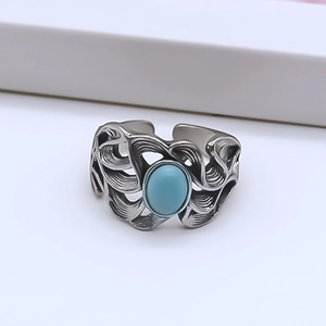 Detail of vintage turquoise ring with wave openwork and oxidized silver finish