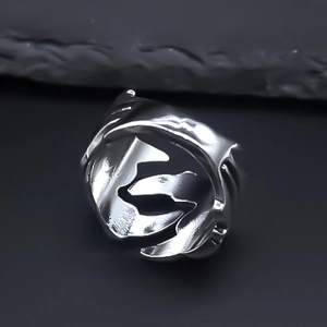 Macro shot of silver eagle claw ring with adjustable band on dark stone background