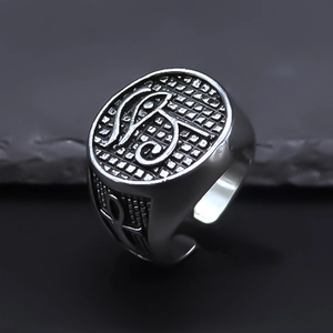 Macro view of vintage punk ring with engraved circular face and mesh relief texture