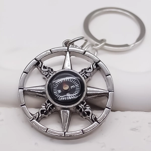 Metallic compass keychain with nautical star design and functional directional dial