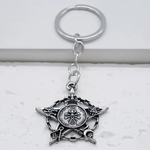 Macro detail of gothic alloy star keychain with skull emblem and mystic symbols