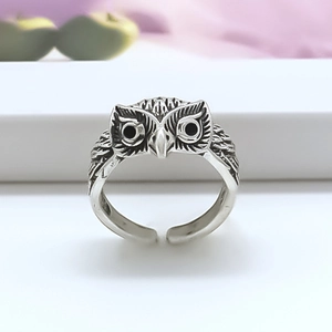 Detailed close-up of retro owl ring in silver alloy with adjustable open band design