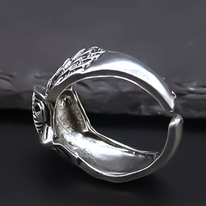 Detailed macro of vintage owl ring with silver feather textures and adjustable band