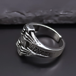 Macro view of vintage silver ring with skull bone relief and engraved rune symbols