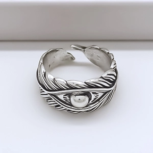 Detail of vintage feather engraved silver ring with an adjustable open band design