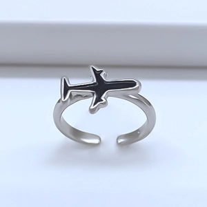 Macro detail of adjustable silver ring featuring a black airplane design on minimalist steps